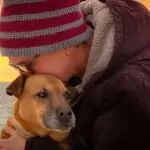 person hugging a dog