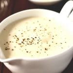 white sauce in a gravy boat seasoned with pepper